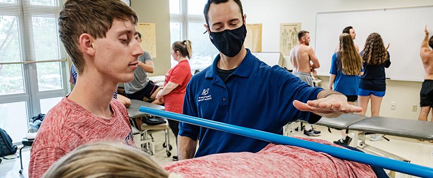 Image of PT Instructor and student in lab.